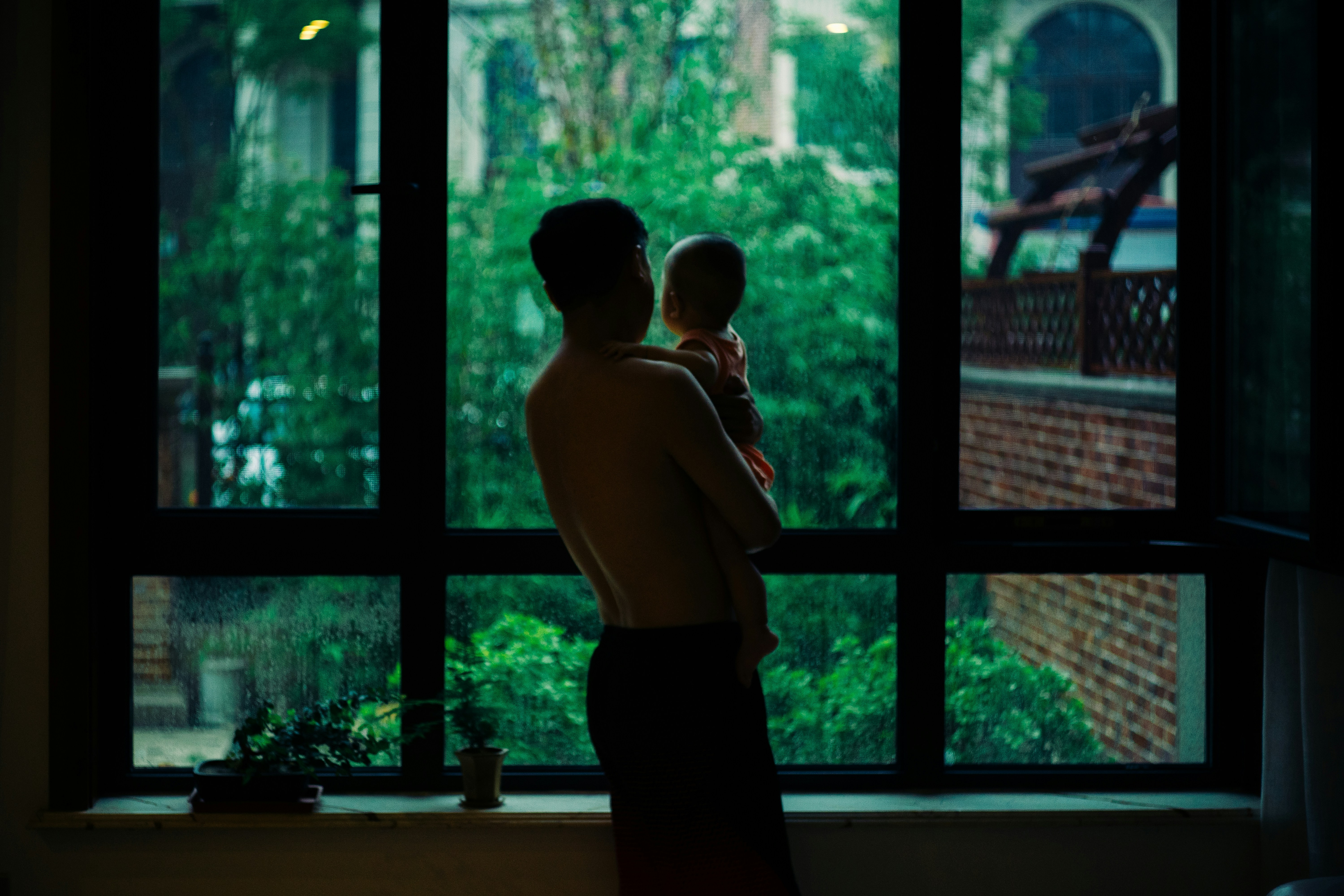 Parent holding a child by the window